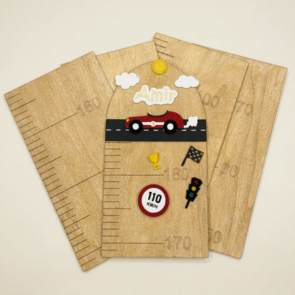 A wooden racing-themed height chart with decorative elements including a red race car, clouds, a sun, a trophy cup, a speed limit sign, and a checkered flag, displayed on a light beige background.